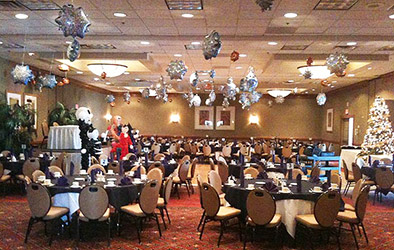 Sparkling mylar snowflake balloons placed accross the ceiling of this holiday party room to create a snowstorm illusion