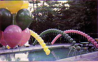 Balloon arches float over a swimming pool as part of the decroation for a yard party