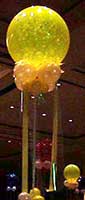 30 inch yellow translucent bubble floating 8' above the venue floor with matching decorative collar and streamers