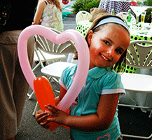 This bright pink heart brings a smile to this young party guest’s face